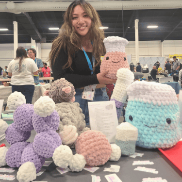 CSOE graduate student Kristine Legaspi poses with her crochet chemistry creations. 